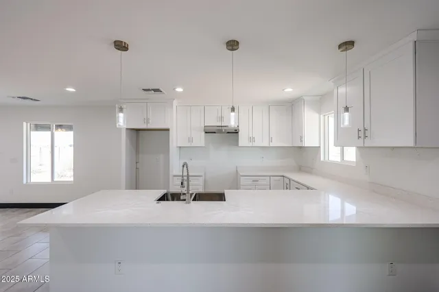a kitchen with stainless steel appliances granite countertop a sink refrigerator and cabinets