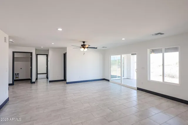 an empty room with windows and cabinet