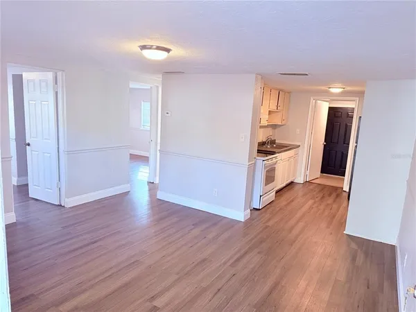 a view of a kitchen with wooden floor and electronic appliances