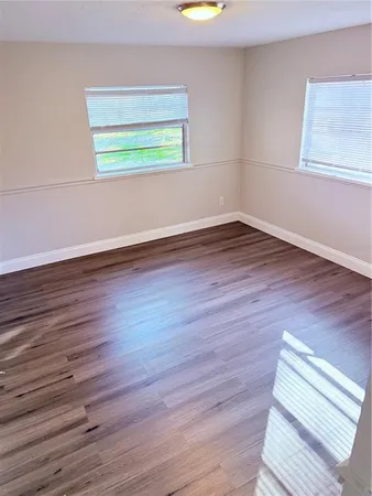 an empty room with wooden floor and a window