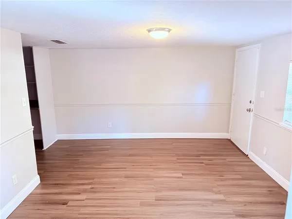 a view of an empty room with wooden floor