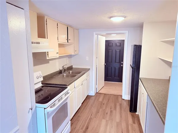 a kitchen with granite countertop a sink and wooden floor