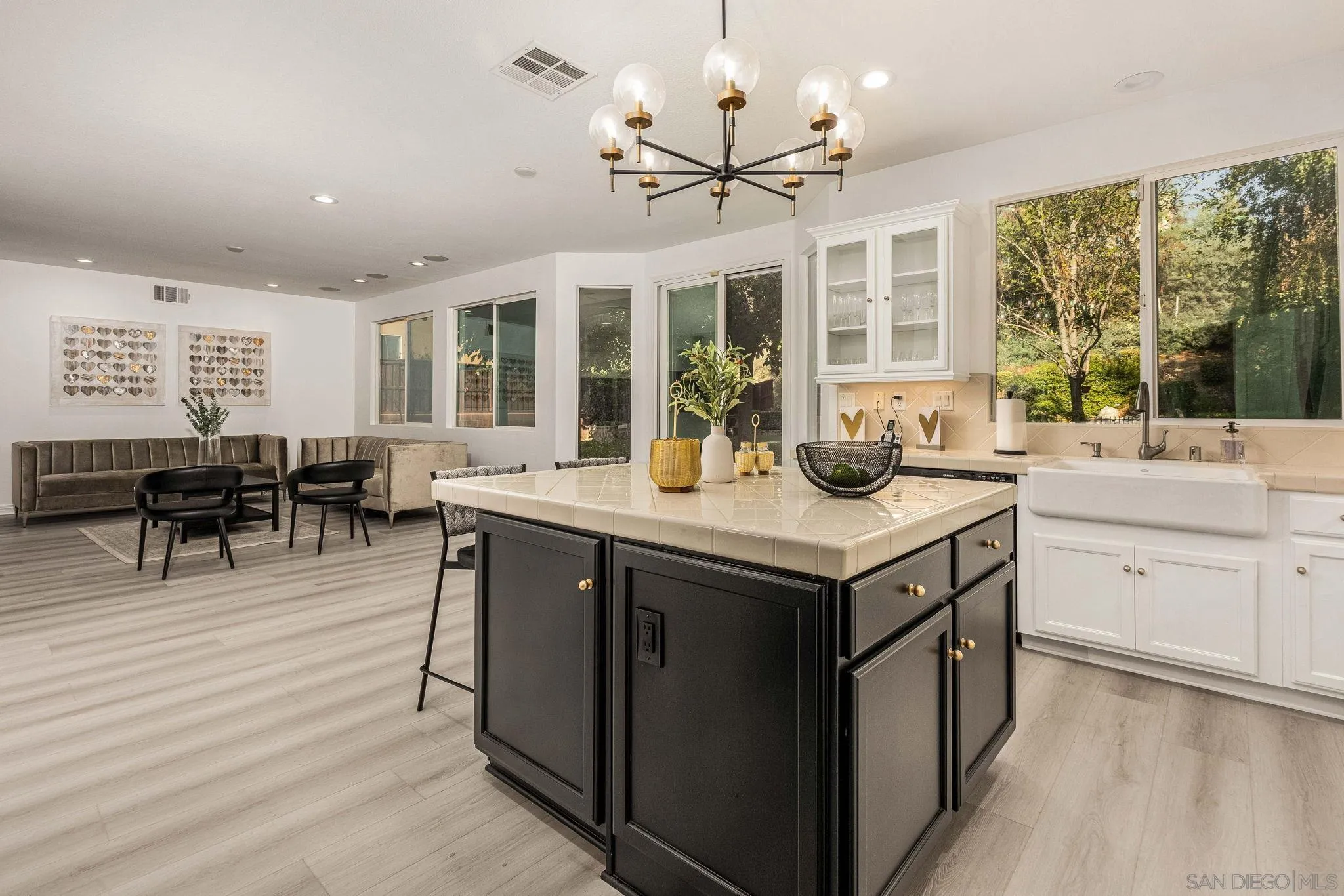 38944 Cherry Point Lane Murrieta, CA 92563 - Photo 7 of 40 a kitchen with a stove a sink dishwasher and a dining table with wooden floor