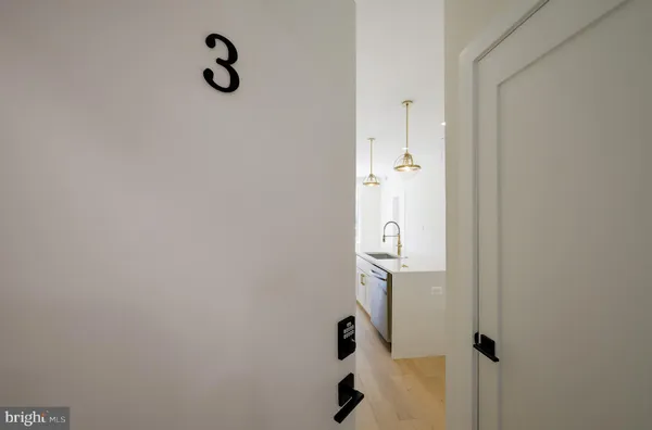 a kitchen with kitchen island granite countertop a stove a sink a center island and wooden floor