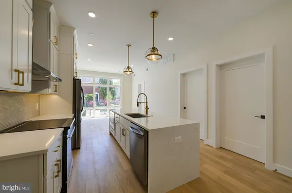 a kitchen with stainless steel appliances a sink a stove a refrigerator and cabinets