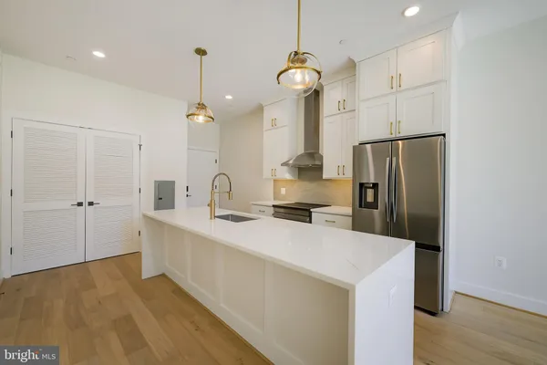 a kitchen with a stove and a wooden floor