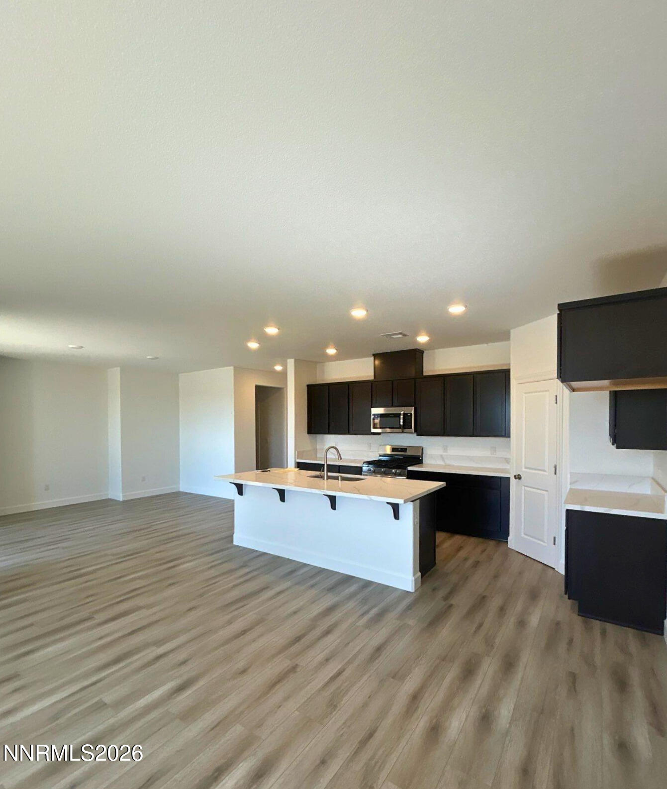 3453 Payton Way Fernley, NV 89408 - Photo 2 of 15 a view of kitchen with kitchen island a sink wooden floor and living room view