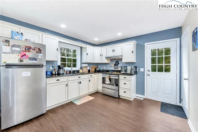 a view of a kitchen and dining room with wooden floor