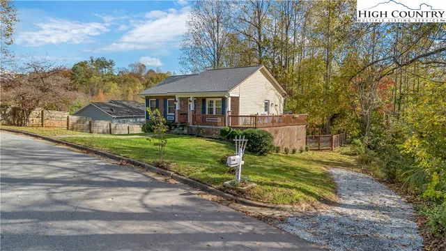 a view of a house with a big yard plants and large trees