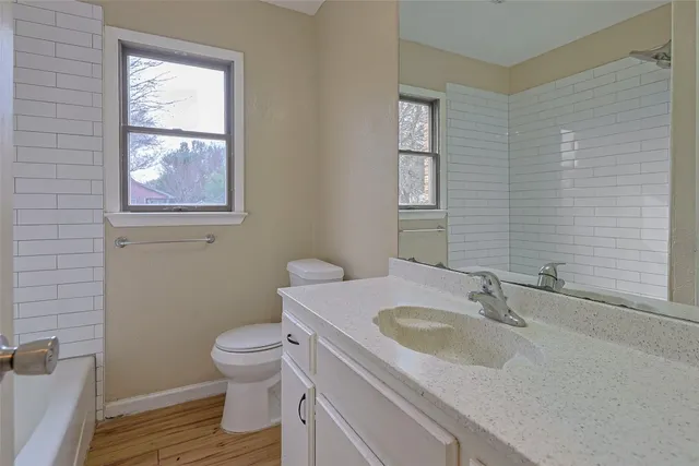a bathroom with a sink toilet and a window