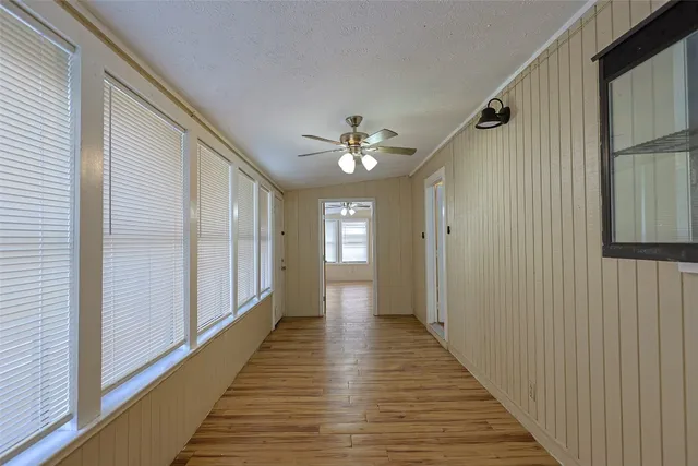 a view of a hallway with wooden floor and staircase