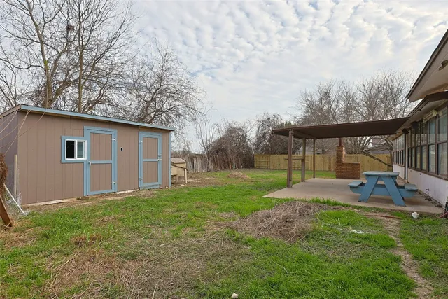 a view of a house with backyard and sitting area
