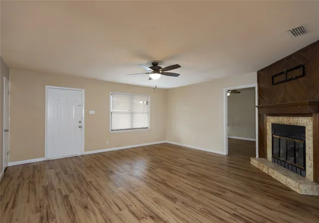 a view of a livingroom with a ceiling fan fireplace and wooden floor