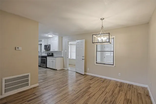 a view of a kitchen with wooden floor a sink and dishwasher