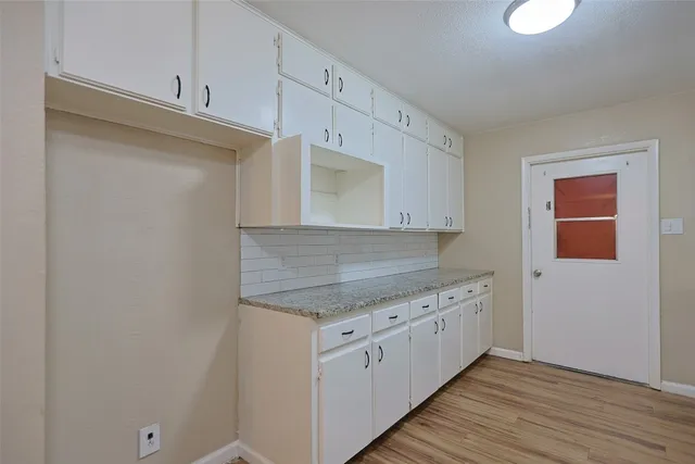 a kitchen with granite countertop a sink and cabinets