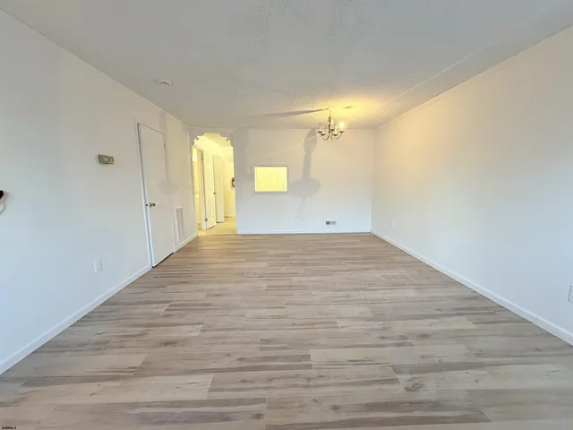 a view of a big room with wooden floor and windows