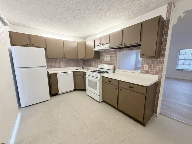 a kitchen with stainless steel appliances granite countertop a refrigerator a stove a sink and a microwave