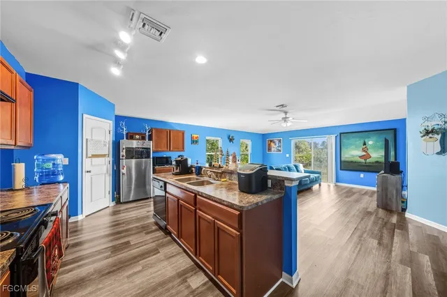 a kitchen with stainless steel appliances granite countertop a stove and a wooden floors