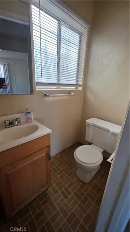 a bathroom with a toilet a sink and a window