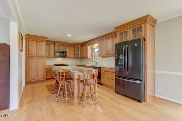 a kitchen with stainless steel appliances granite countertop a refrigerator and a stove top oven
