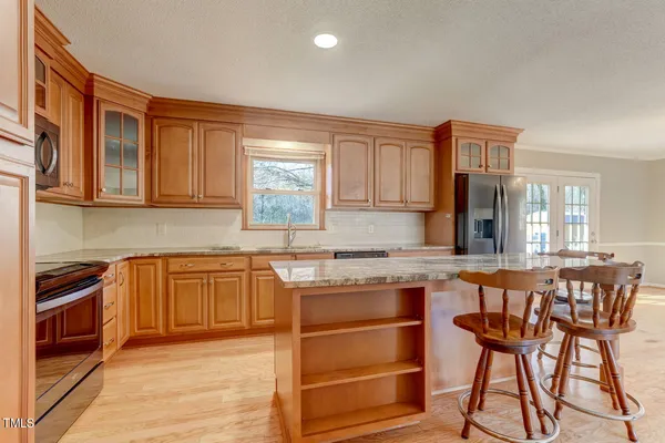 a kitchen with stainless steel appliances granite countertop wooden cabinets and a refrigerator