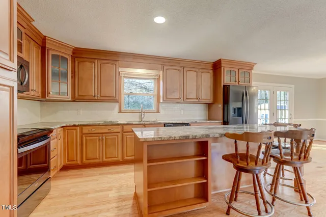 a kitchen with stainless steel appliances granite countertop wooden cabinets and a refrigerator