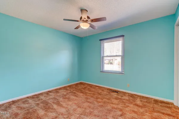 a view of a big room with windows and ceiling fan