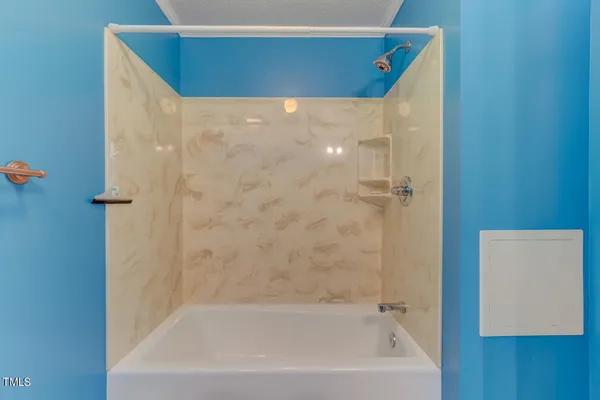 a view of an empty room with a fireplace and a window