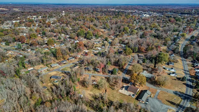 an aerial view of residential house with parking and yard