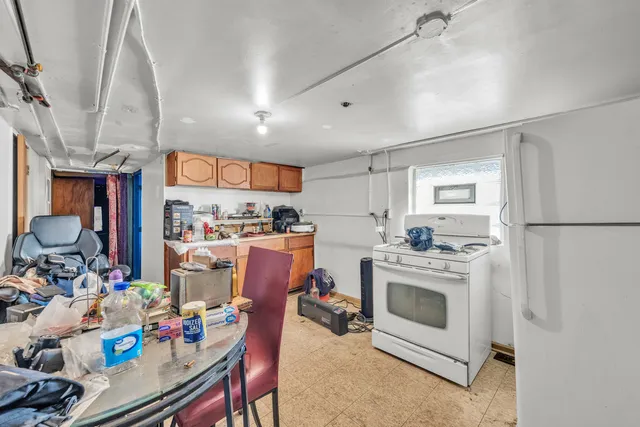 a kitchen with a dining table chairs stove and white cabinets