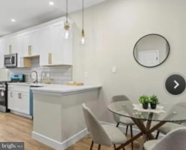 a kitchen with a table chairs sink and cabinets