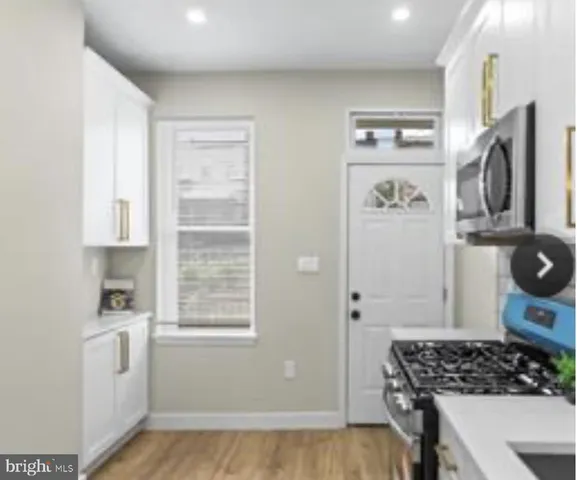a kitchen with white cabinets and a stove top oven