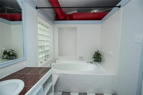 a bathroom with a granite countertop tub and a shower
