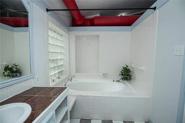 a bathroom with a granite countertop tub and a shower
