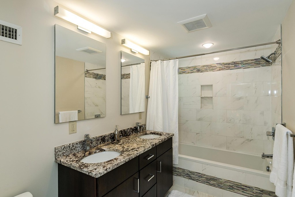 87 Beverly Road Brookline, MA 02467 - Photo 14 of 16 a bathroom with a shower sink vanity and mirror