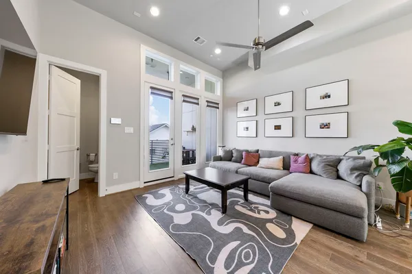 a living room with furniture a flat screen tv and a floor to ceiling window