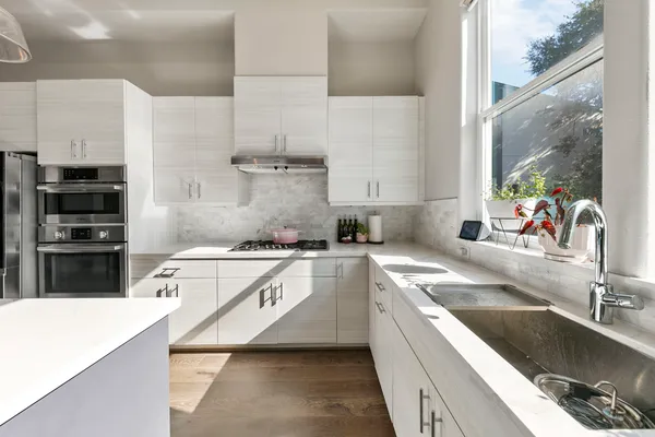 a kitchen with a stove a refrigerator and a dining table with wooden floor