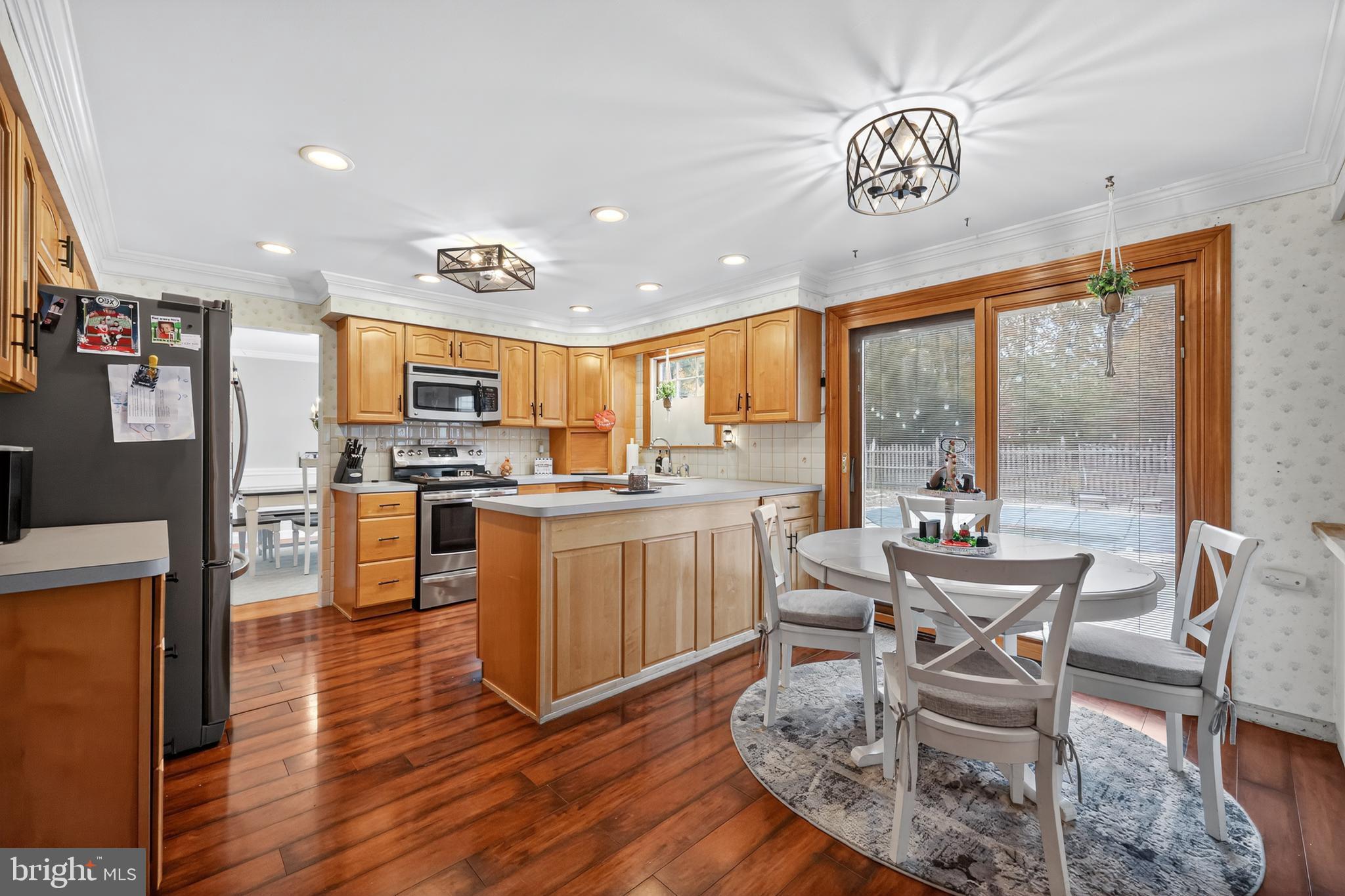 665 Chatham Road Somerdale, NJ 08083 - Photo 11 of 36 a kitchen with stainless steel appliances granite countertop a stove top oven a sink a dining table and chairs with wooden floor