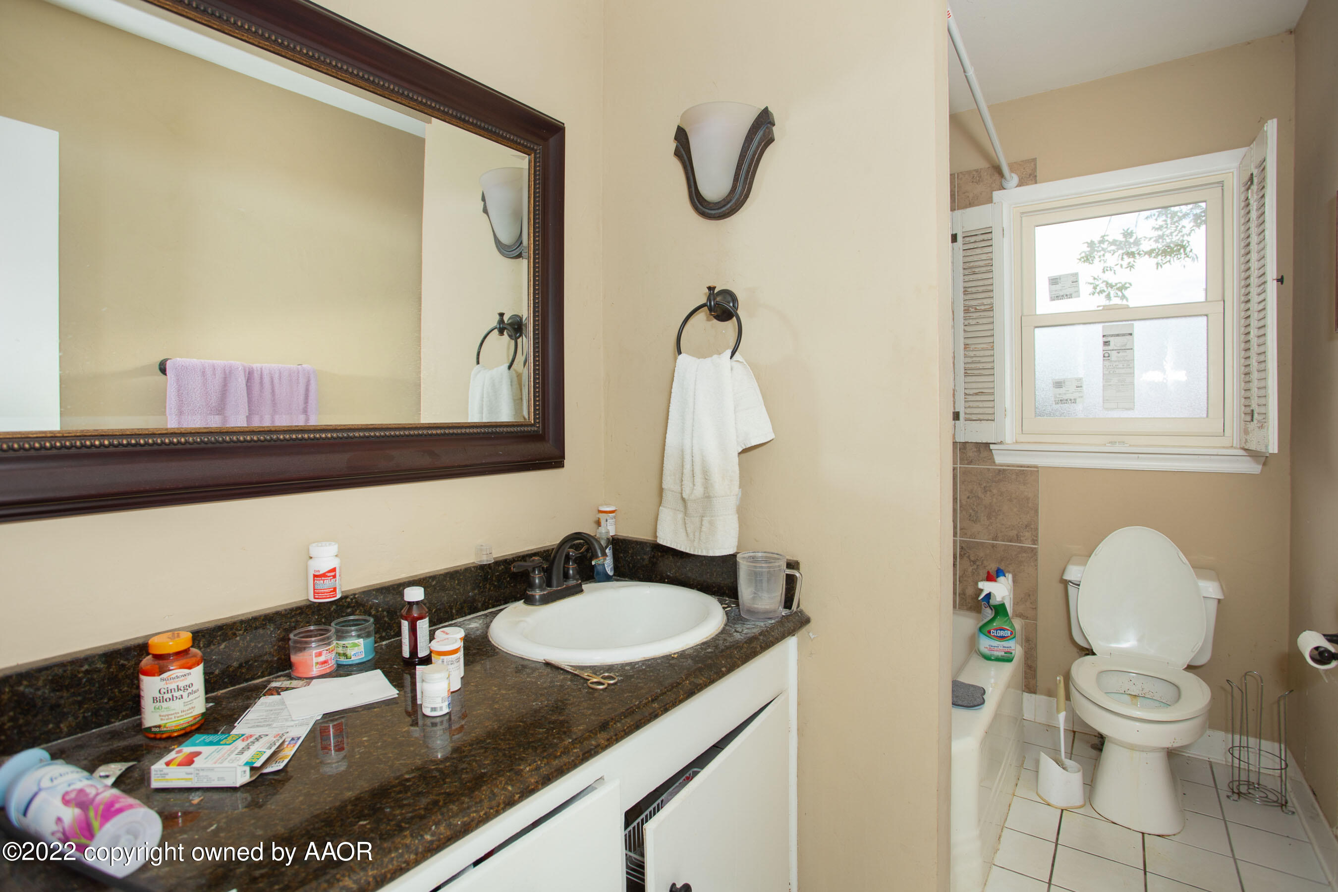 3607 Patterson Drive Amarillo, TX 79109 - Photo 15 of 24 a bathroom with a granite countertop sink toilet and a mirror