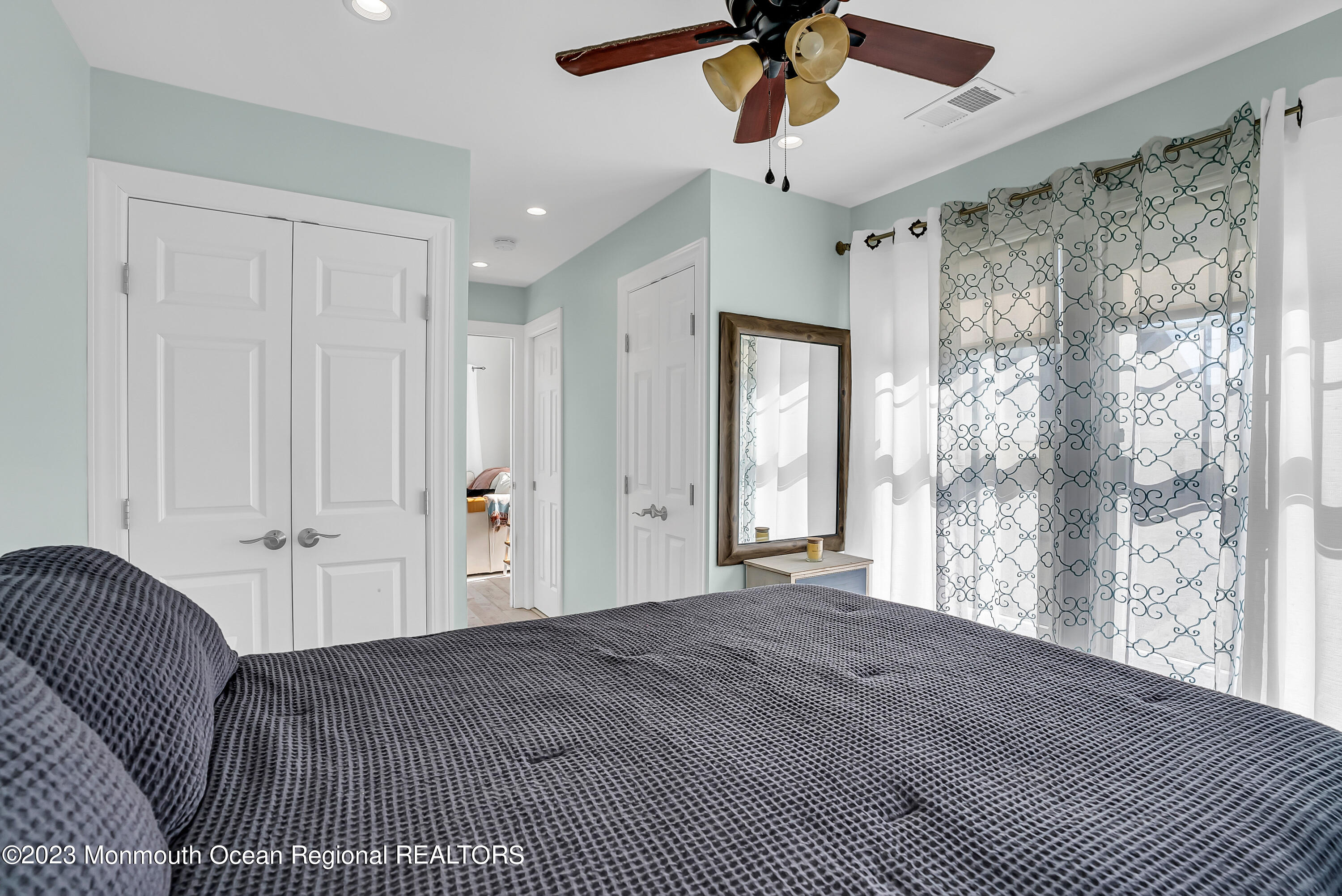 26 East Shell Way Lavallette, NJ 08735 - Photo 19 of 46 a spacious bedroom with a large bed and a chandelier