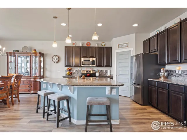 a kitchen with stainless steel appliances kitchen island granite countertop a refrigerator and a stove top oven