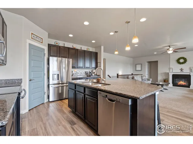 a kitchen with stainless steel appliances granite countertop a sink a refrigerator and a stove