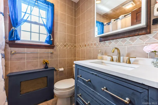 a bathroom with a sink a toilet and a window