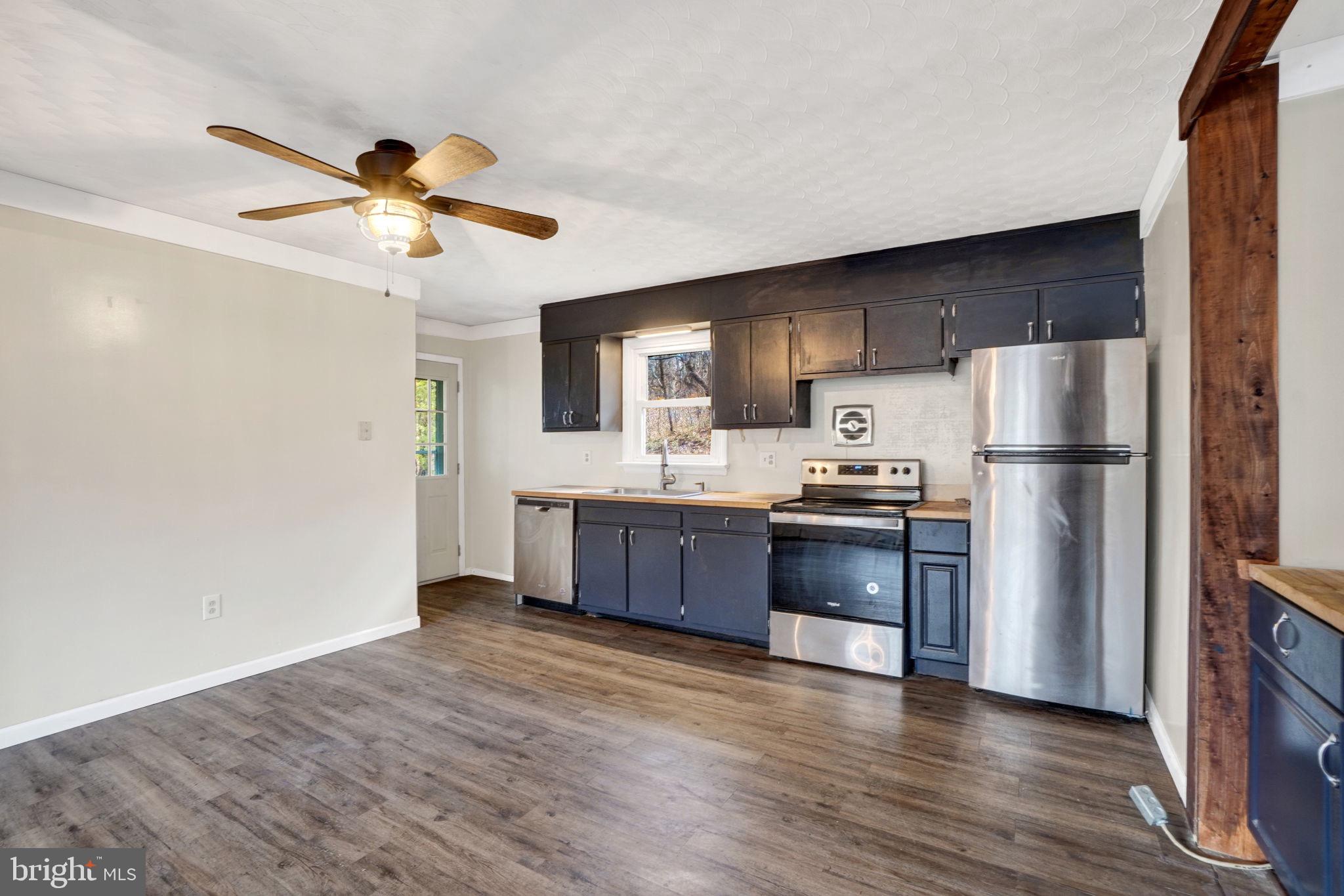 5714 Spruce Road Felton, PA 17322 - Photo 10 of 33 a kitchen with stainless steel appliances granite countertop a refrigerator a sink dishwasher a stove with wooden floors