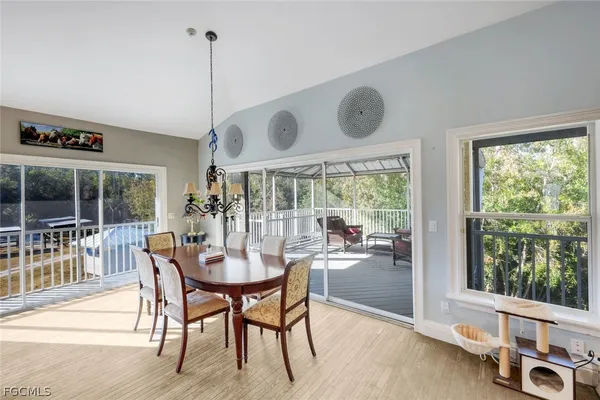 a view of a dining room and livingroom with furniture wooden floor a chandelier