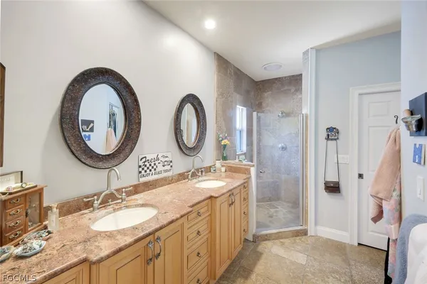 a bathroom with a granite countertop double vanity sink and a mirror