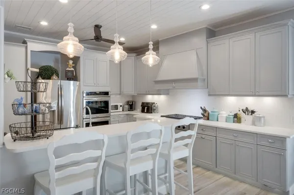 a kitchen with kitchen island granite countertop a sink cabinets and stainless steel appliances