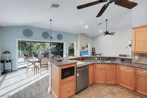 a kitchen with a stove a sink a kitchen island with chairs and wooden floor