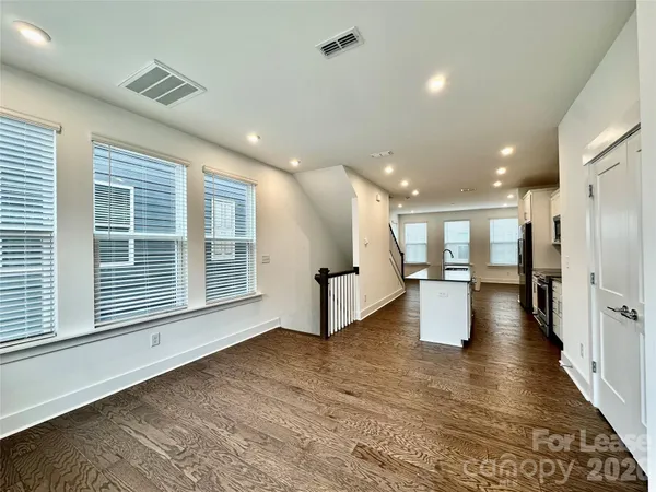 a view of a big room with wooden floor and windows