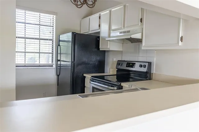 a kitchen with stainless steel appliances a refrigerator sink and cabinets